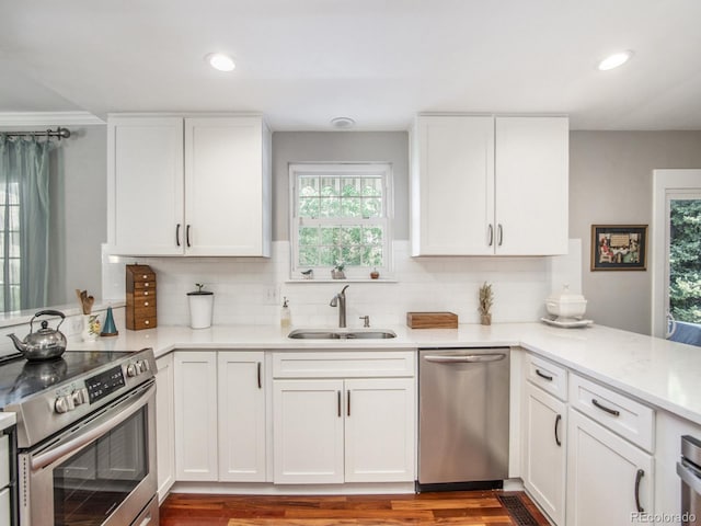 kitchen with appliances with stainless steel finishes, sink, and white cabinetry