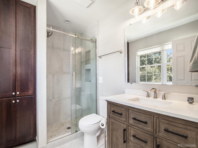 bathroom featuring vanity, toilet, a shower with door, and tile patterned floors