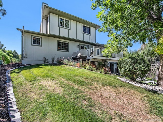 rear view of house with a deck and a yard