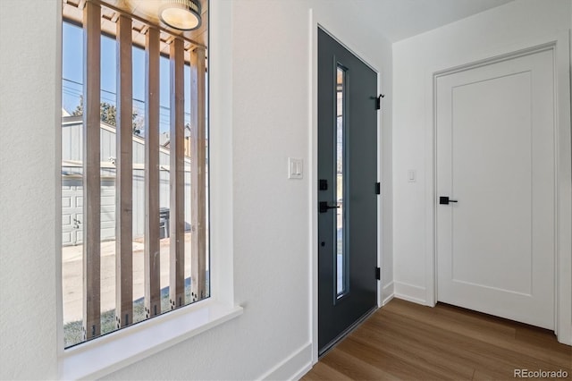 entryway featuring a wealth of natural light, baseboards, and dark wood-style flooring