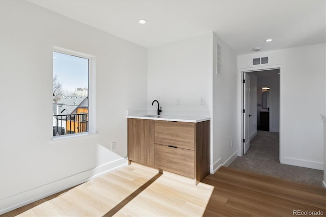 bathroom with visible vents, recessed lighting, baseboards, and wood finished floors