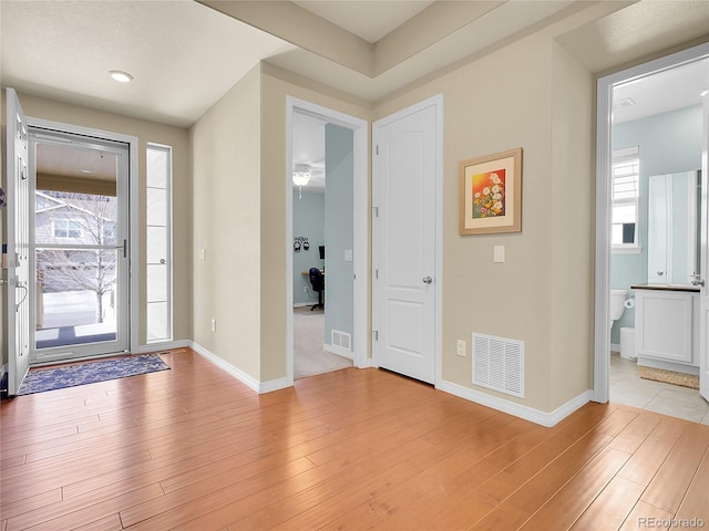 entrance foyer with light wood-style flooring, visible vents, and baseboards