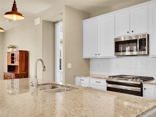 kitchen with backsplash, white cabinetry, stainless steel appliances, and a sink