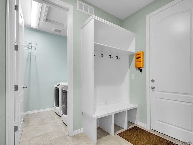 mudroom featuring attic access, visible vents, baseboards, separate washer and dryer, and light tile patterned flooring