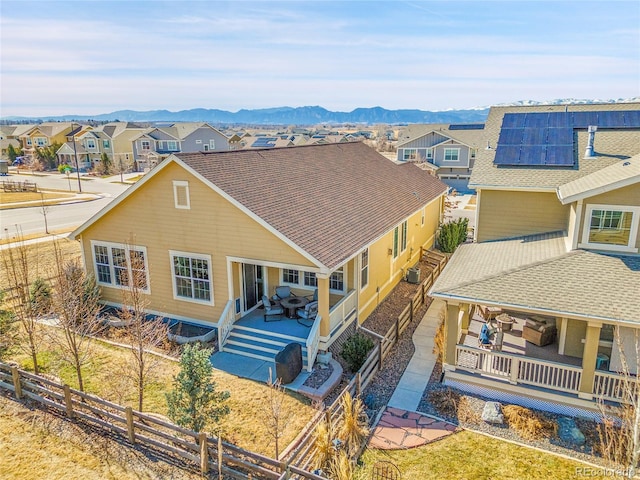 view of front facade with a shingled roof, a residential view, a fenced backyard, and a mountain view