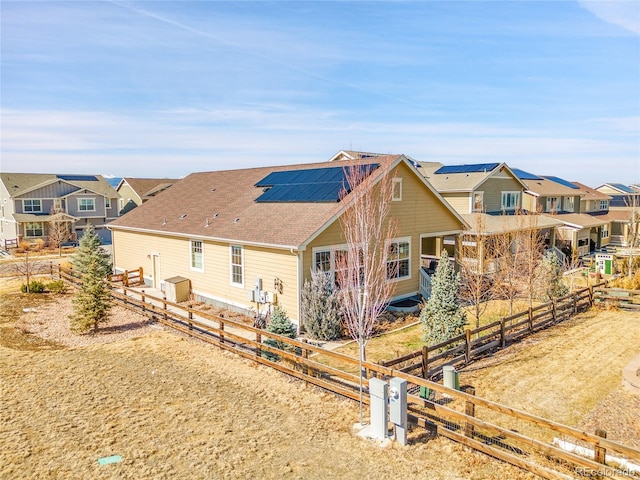 view of front of house featuring a residential view and solar panels