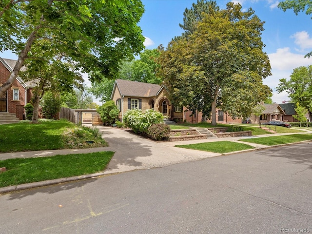 tudor home featuring a front lawn