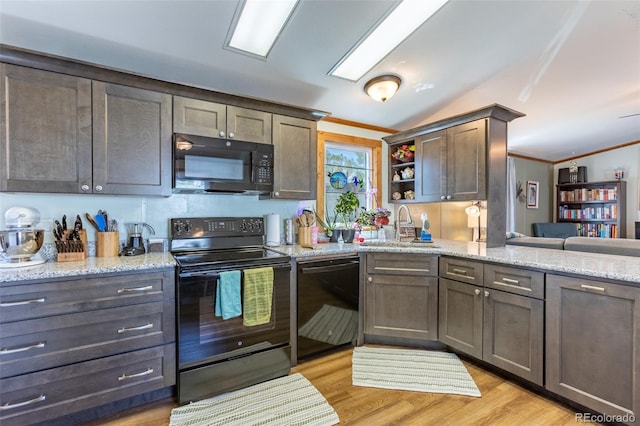 910 J St Unit D1, Salida, CO 81201 - kitchen with black appliances, crown molding, a sink, vaulted ceiling, and light stone countertops
