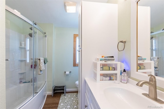 910 J St Unit D1, Salida, CO 81201 - bathroom featuring toilet, wood finished floors, shower / bath combination with glass door, vanity, and baseboards
