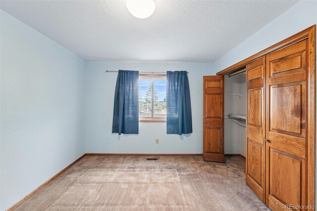 2100 Bibles Hill Dr, Franktown, CO 80116 - unfurnished bedroom featuring light carpet, baseboards, and a textured ceiling
