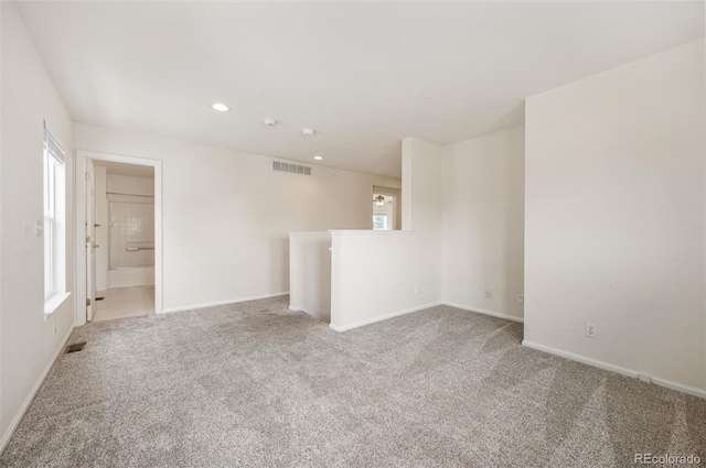 empty room featuring light carpet, recessed lighting, visible vents, and baseboards
