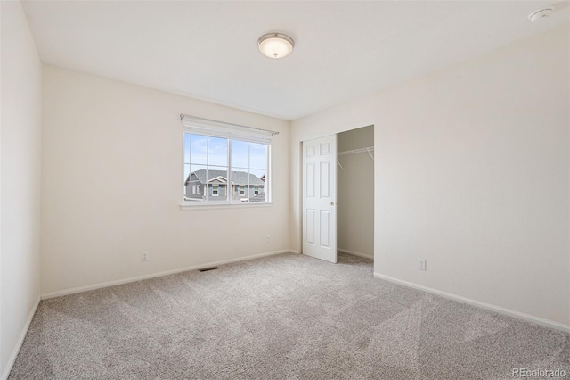 unfurnished bedroom with a closet, carpet flooring, visible vents, and baseboards