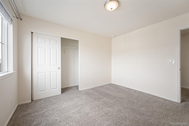 unfurnished bedroom with a closet, baseboards, and carpet