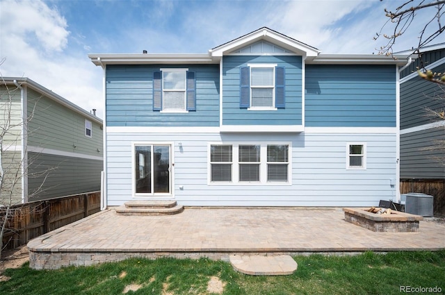 rear view of house featuring an outdoor fire pit, a patio area, fence, and central AC