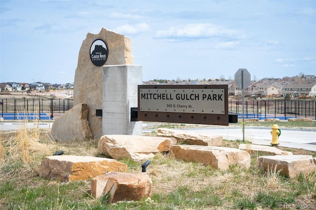 community sign featuring a residential view and fence