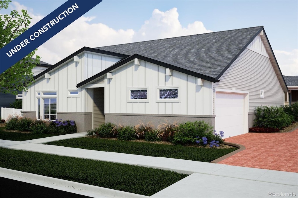 21835 E 51st Dr, Aurora, CO 80019 - view of front of property with board and batten siding, roof with shingles, a garage, and decorative driveway