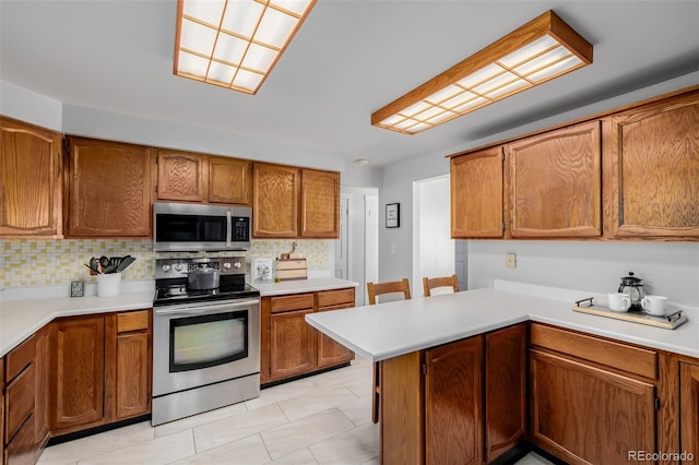 kitchen with decorative backsplash, kitchen peninsula, and appliances with stainless steel finishes