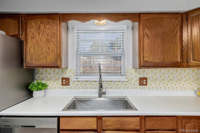 kitchen with tasteful backsplash, sink, and stainless steel dishwasher