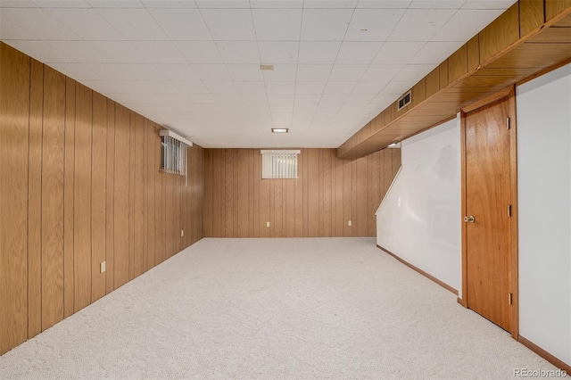 basement with carpet floors and wood walls