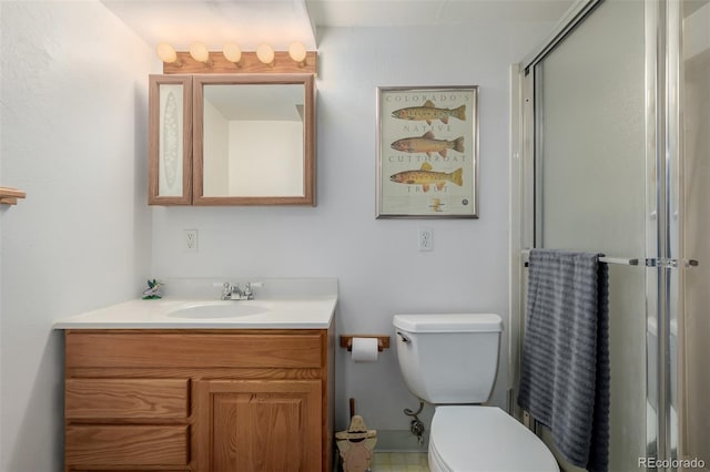 bathroom with vanity, a shower with shower door, and toilet