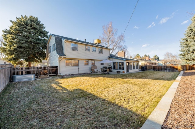 rear view of house featuring a yard and a patio