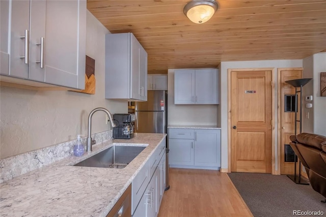 13 Paradise Rd, Crested Butte, CO 81225 - kitchen featuring wooden ceiling, light wood-type flooring, light stone countertops, and freestanding refrigerator