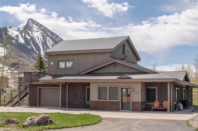 13 Paradise Rd, Crested Butte, CO 81225 - view of front facade featuring a mountain view, a porch, an attached garage, stairway, and driveway