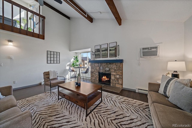 living area featuring beam ceiling, a wall unit AC, a baseboard heating unit, a stone fireplace, and wood finished floors