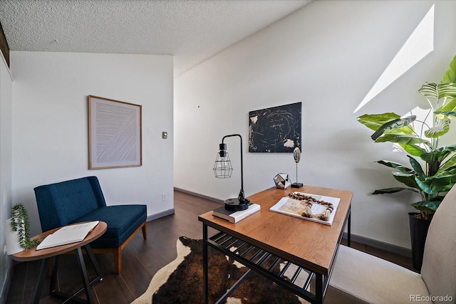 office space with a textured ceiling, baseboards, vaulted ceiling, and wood finished floors