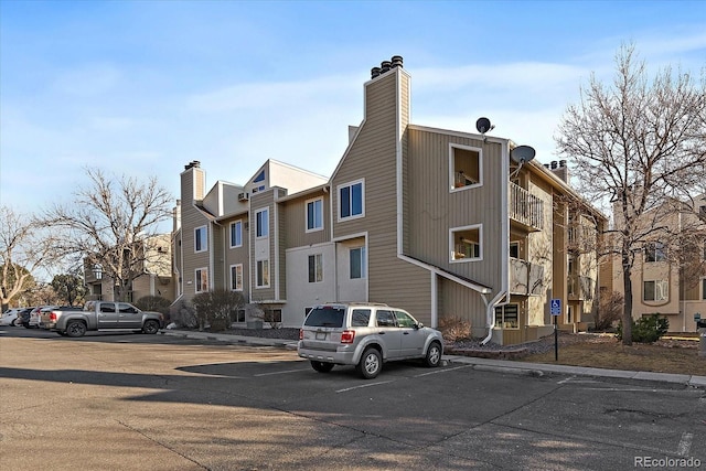 view of property featuring uncovered parking and a residential view