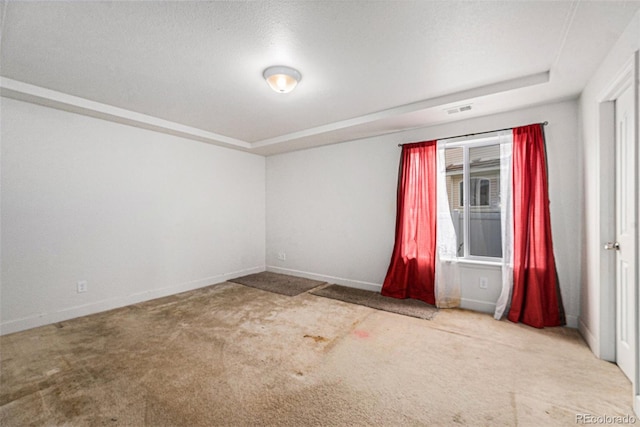 unfurnished room with carpet, visible vents, and baseboards