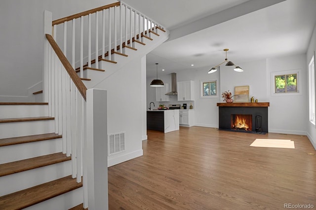 staircase featuring wood-type flooring and sink