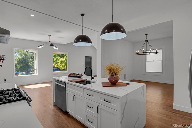 kitchen featuring light stone counters, white cabinets, pendant lighting, wood-type flooring, and sink