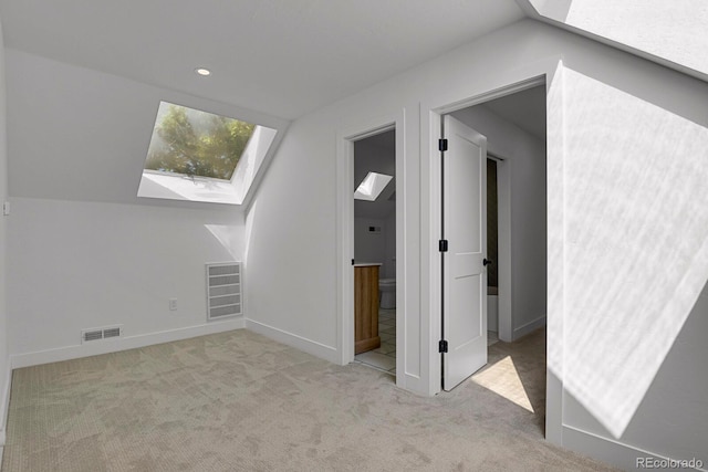 bonus room featuring vaulted ceiling with skylight and light carpet