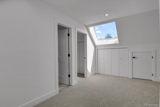 additional living space with light carpet and lofted ceiling with skylight