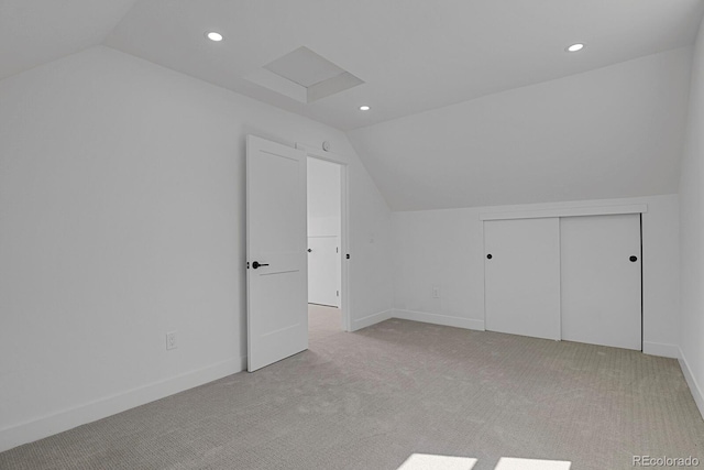 bonus room with vaulted ceiling and light colored carpet