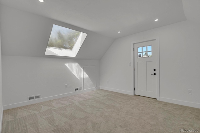 bonus room with light carpet and lofted ceiling with skylight