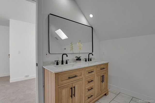 bathroom with vanity and vaulted ceiling with skylight