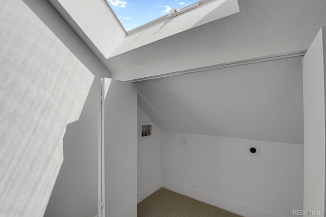 bonus room with vaulted ceiling with skylight and carpet flooring