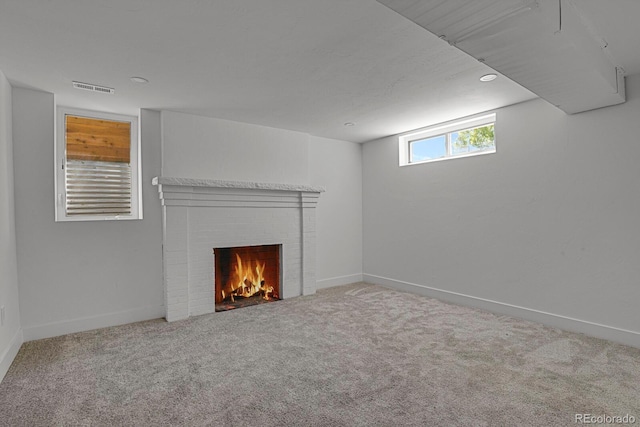 unfurnished living room with carpet floors and a brick fireplace