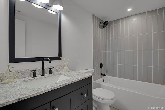 full bathroom with vanity, tiled shower / bath combo, and toilet