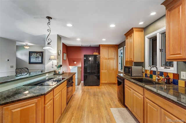 1161 S Johnson Way, Lakewood, CO 80232 - kitchen with black appliances, light wood-type flooring, dark stone countertops, decorative light fixtures, and recessed lighting