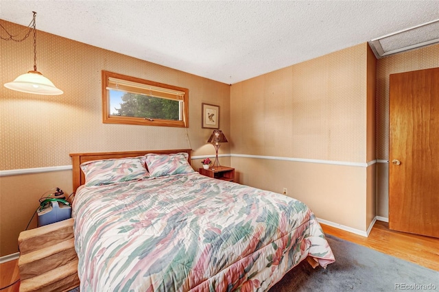 1161 S Johnson Way, Lakewood, CO 80232 - bedroom with wood finished floors, a textured ceiling, and wallpapered walls
