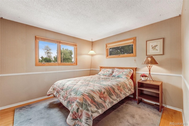 1161 S Johnson Way, Lakewood, CO 80232 - bedroom featuring a textured ceiling, wood finished floors, and wallpapered walls