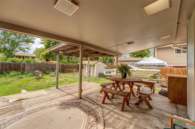 1161 S Johnson Way, Lakewood, CO 80232 - fenced backyard featuring a storage shed, a wooden deck, and outdoor dining space