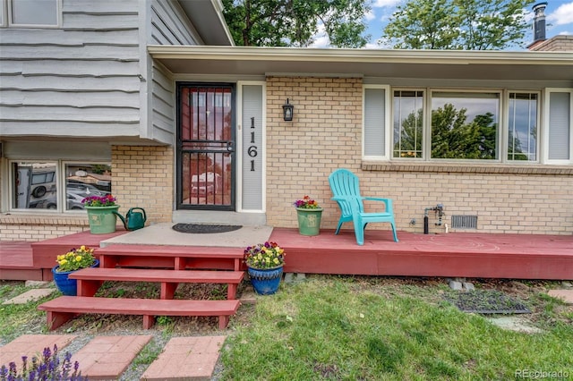 1161 S Johnson Way, Lakewood, CO 80232 - view of exterior entry with brick siding and a deck