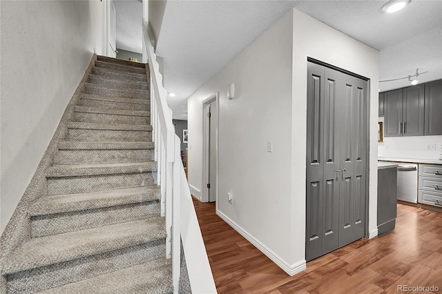 1711 Cato Cir Unit 21, Lafayette, CO 80026 - stairs with wood finished floors, a textured ceiling, rail lighting, and recessed lighting