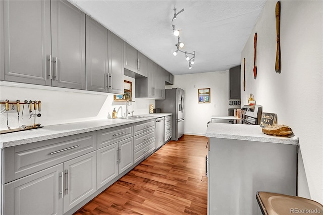 1711 Cato Cir Unit 21, Lafayette, CO 80026 - kitchen featuring gray cabinets, stainless steel appliances, light wood finished floors, and light countertops