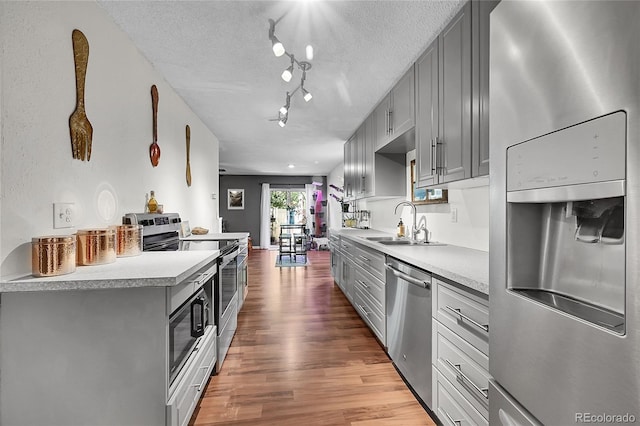 1711 Cato Cir Unit 21, Lafayette, CO 80026 - kitchen with stainless steel appliances, gray cabinets, light wood finished floors, light countertops, and a textured ceiling