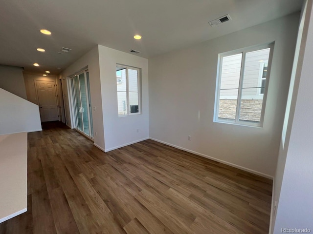 spare room featuring dark wood-type flooring and a wealth of natural light